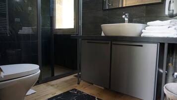 A modern bathroom with a toilet, a sink, and a shower.