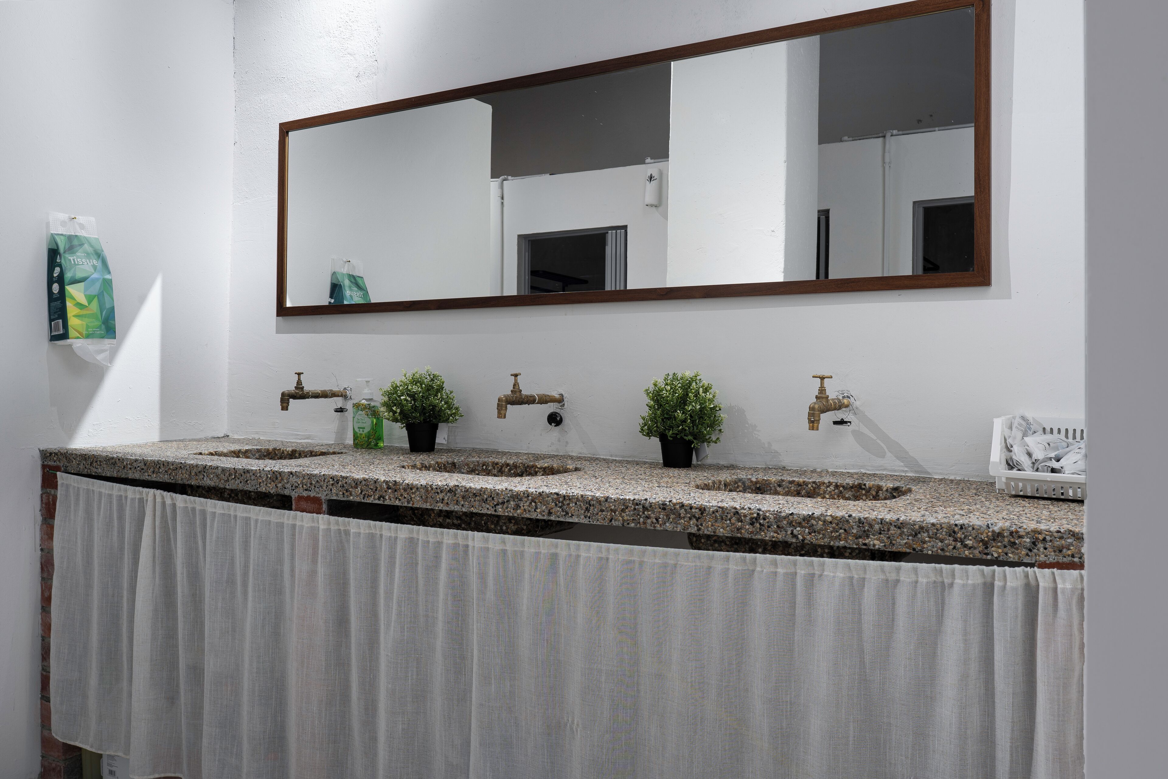 A bathroom with two sinks, a large mirror, and a towel rack.