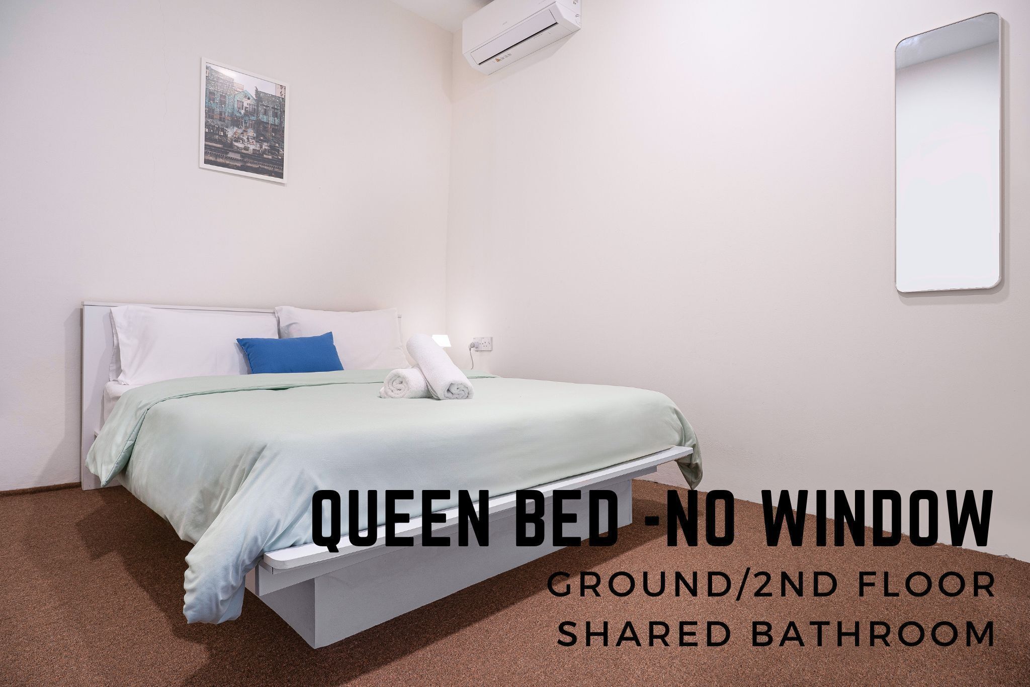 Een queensize bed zonder raam, gelegen op de begane grond of tweede verdieping, met een gedeelde badkamer.
