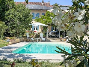 A swimming pool with lounge chairs, a table, and a building with blue shutters in the background. - Wonderful private villa for 2 guests with WIFI, A/C, pool, TV, patio and panoramic view (San Damiano D'asti)