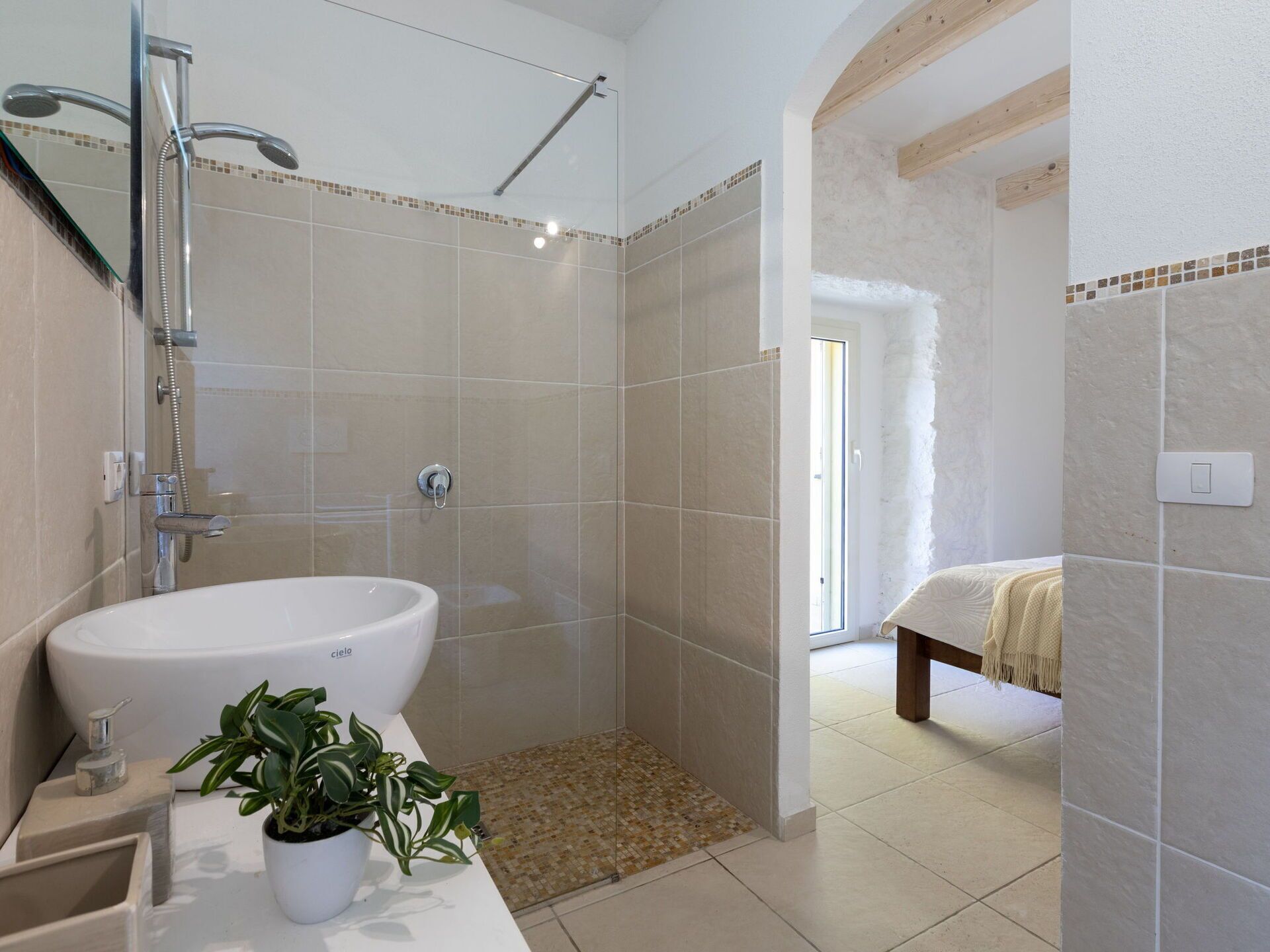 Une salle de bain moderne avec un grand lavabo, une douche et un petit banc.