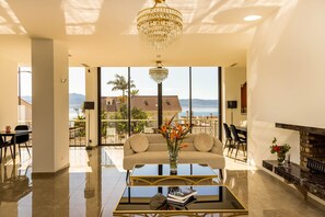 Un salón amplio con sofá, mesa de centro y vista al mar.