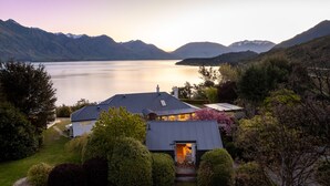 Propiedad junto al lago con una casa que tiene una terraza amplia y vistas al lago y a las montañas.
