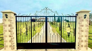 A gated entrance with a gravel path leading through. - LPMDC - A haven of charm and authenticity in the heart of nature (Salerm)
