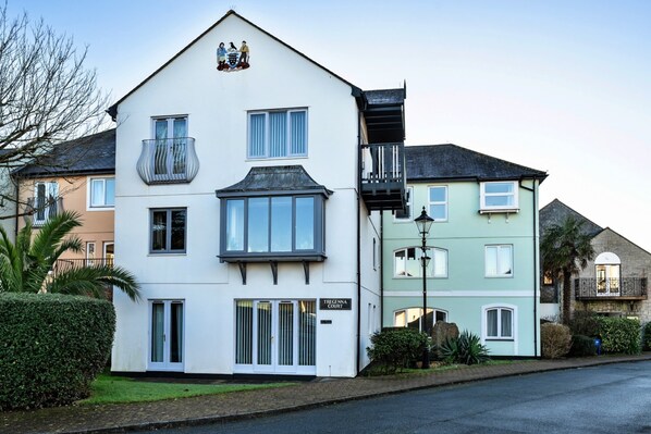 A two-story building with a balcony, a sign reading 'Tregenn Court,' and a street view with other buildings. - Apartment in Falmouth Near Beaches & Harbour (Falmouth)