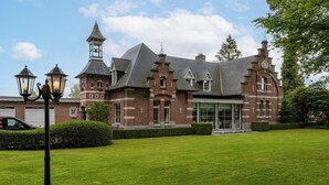 Ein großes Backsteingebäude mit einem markanten Turm und einem modernen Glaseingang.