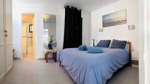A bedroom with a bed, bedside table, and a painting on the wall. - Apartment Florencia With Pool & Wifi in Puerto del Carmen, Lanzarote (Tías)