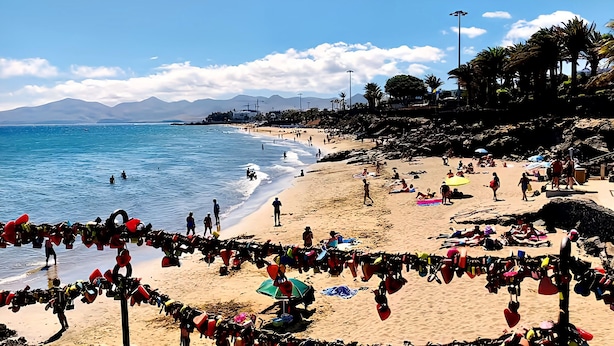 A beach with people, umbrellas, and beach chairs. - Apartment Florencia With Pool & Wifi in Puerto del Carmen, Lanzarote (Tías)