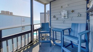 A balcony with a view of the ocean, blue chairs, a small table, and decorative starfish on the wall. - Sea Oaks 308 - Two Bedroom, Two Bath Corner Oceanfront Condo (Garden City Beach)