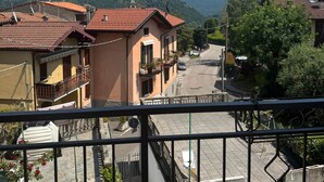 A residential area with houses, a street, and mountains in the background. - Sormano 2 - THE V Collection Apartment by OGS (Sormano)