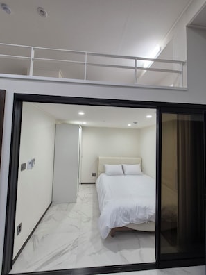 Relax in a serene bedroom with a large bed and balcony access.
