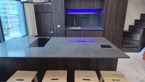 A modern kitchen with a central island, built-in oven, and bar stools. - A comfortable house,  Dongdaemun History & Culture Park Station (Seoul)