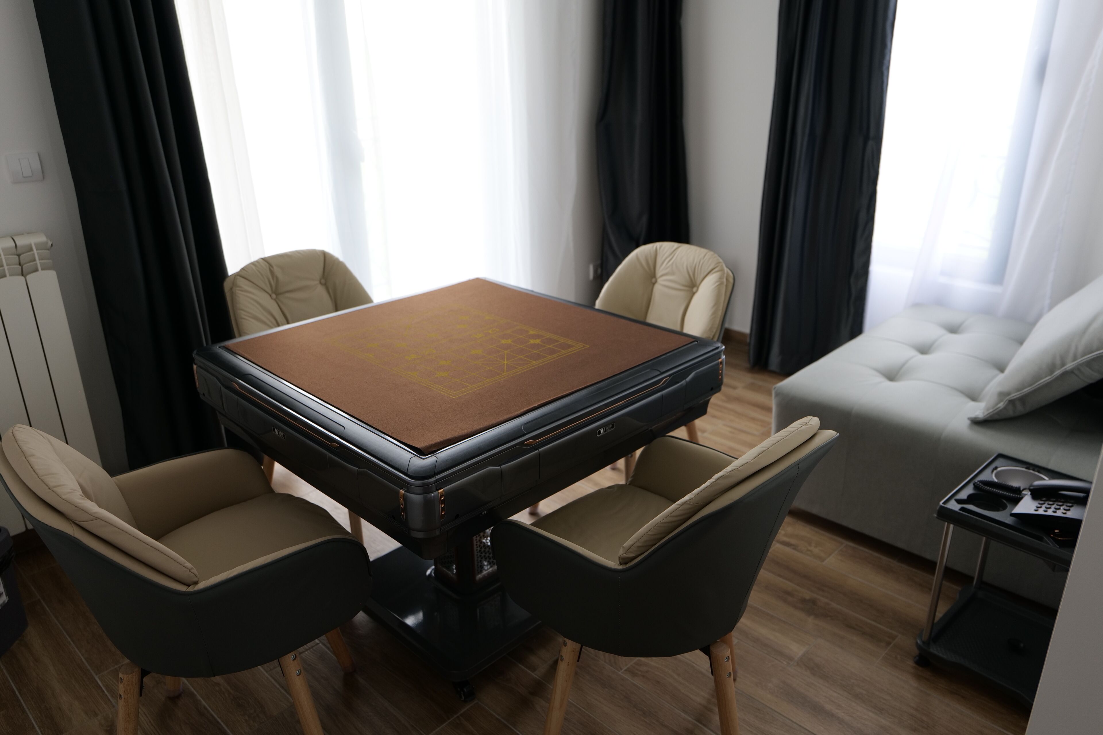 Un espace repas moderne comprenant une grande table, quatre chaises et un canapé.