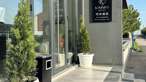 The exterior of Kimly Hotel with a modern facade, large windows, and potted plants. - KIMMIY HOTEL (Belgrade)