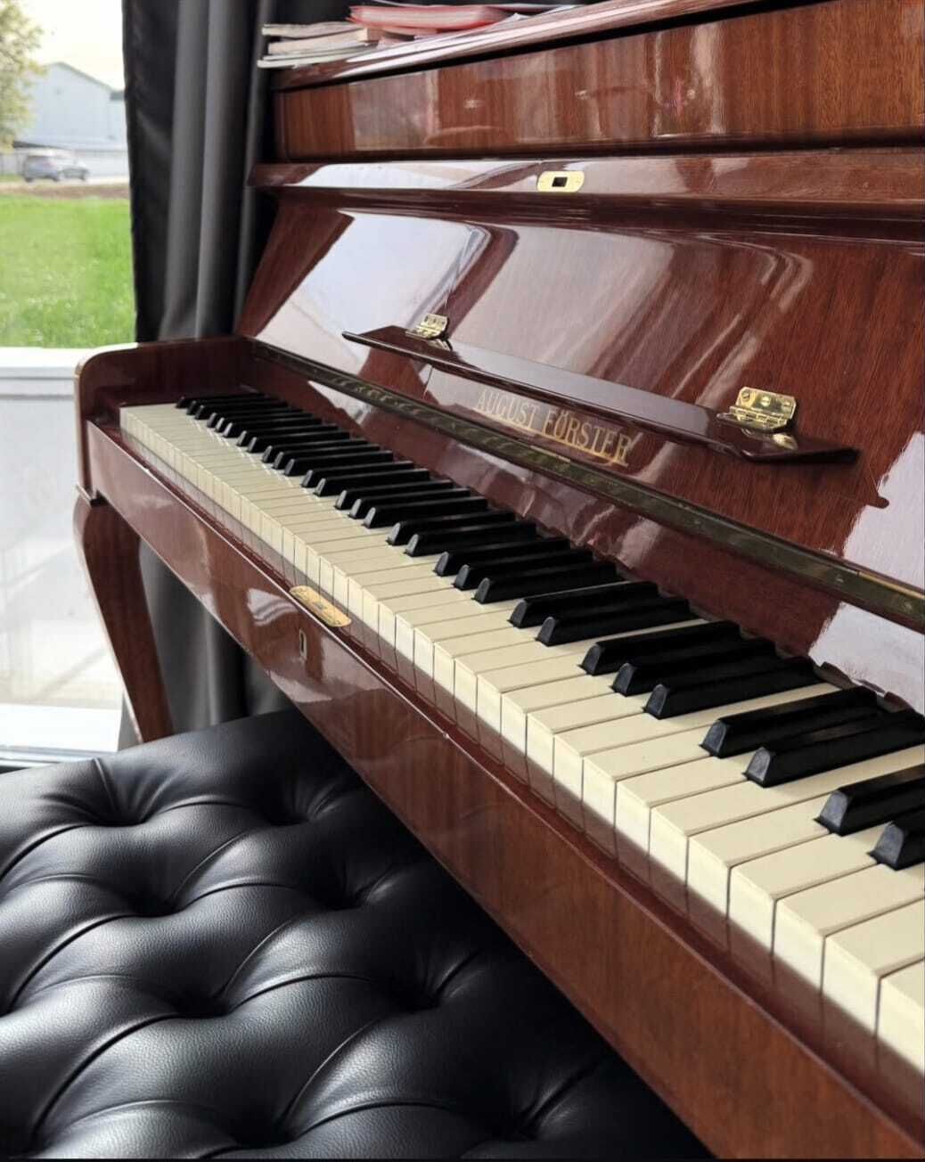 A grand piano with a black cushioned bench.