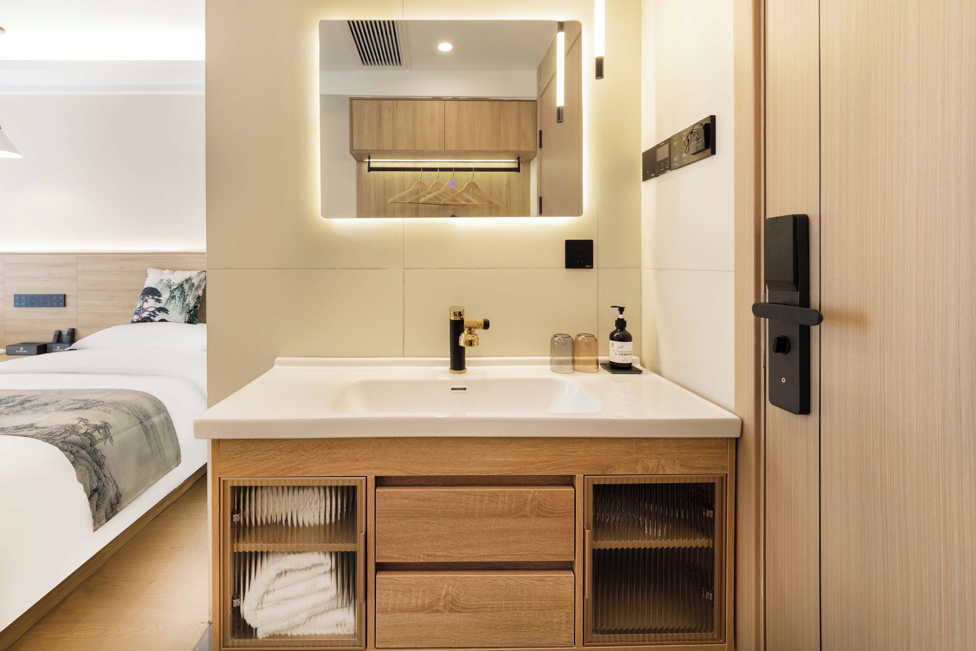 A modern bathroom with a large sink, wooden cabinetry, a mirror, and a towel rack.