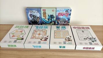 Four board games with Chinese text and panda illustrations on a wooden table.
