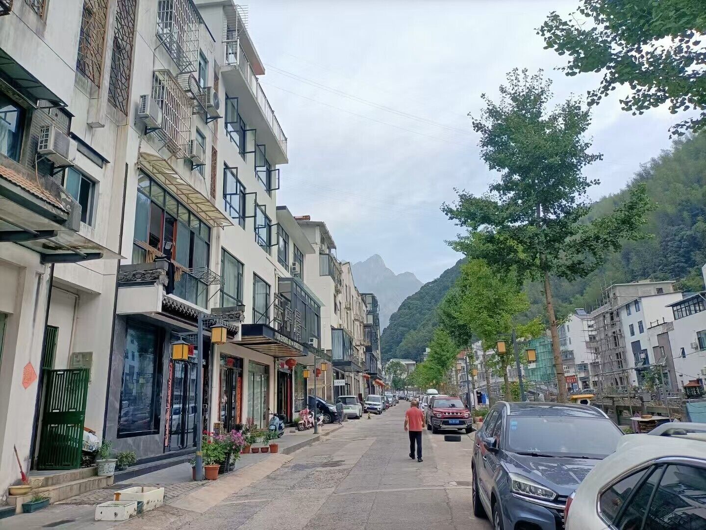 A street lined with multi-story buildings, some with balconies and air conditioning units.