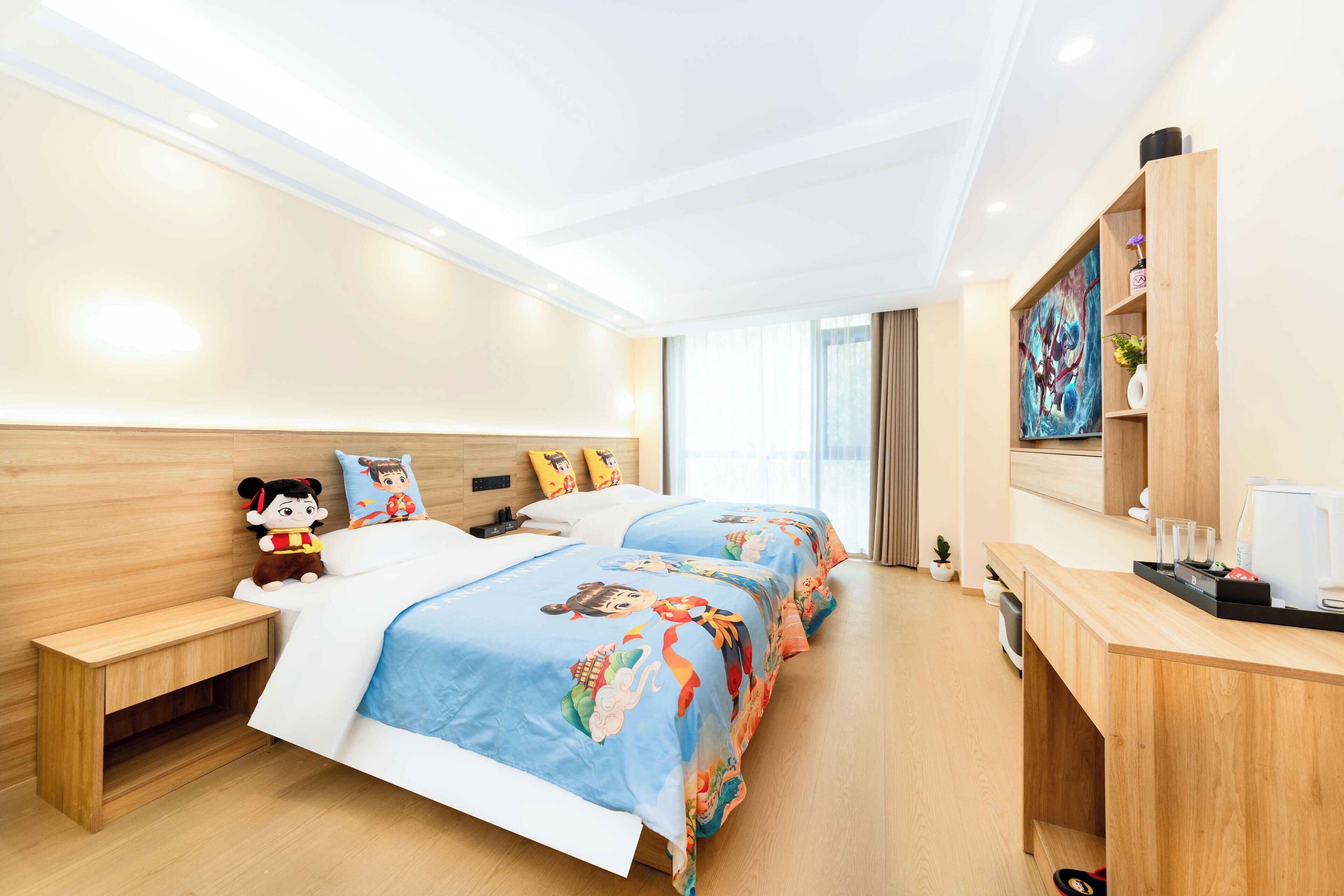 Une chambre d’hôtel avec deux lits, une table de chevet en bois, un bureau avec une machine à café et un tableau au mur.