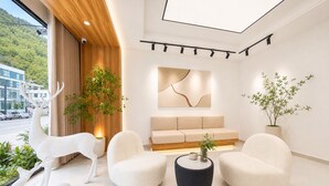 A modern interior with a sofa, chairs, a coffee table, and decorative deer statues. - Mount Huangshan Danqing Yayuan B&B Hotel (Huangshan)