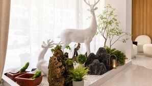 A modern interior with a deer sculpture, potted plants, and a wooden accent wall. - Mount Huangshan Danqing Yayuan B&B Hotel (Huangshan)