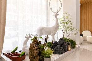 A modern interior with a deer sculpture, potted plants, and a wooden accent wall. - Mount Huangshan Danqing Yayuan B&B Hotel (Huangshan)
