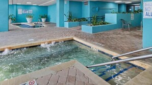 An indoor swimming pool area with a hot tub, tiled flooring, and blue walls. - LA4 Great Studio on the beach + Pool (Myrtle Beach)