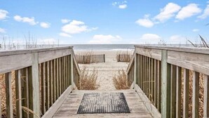 A wooden boardwalk leading to a sandy beach with a clear sky. - LA4 Great Studio on the beach + Pool (Myrtle Beach)