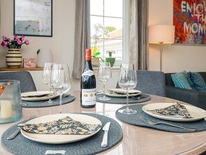 A dining table set with plates, cutlery, and wine glasses, with a bottle of wine in the center. - 4 Star Holiday Home in Laeso (Læsø)