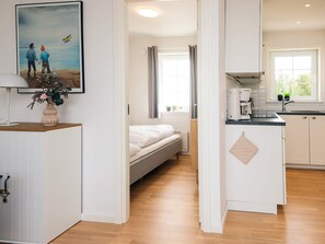 A modern interior with a bed, a kitchenette, and a dining area. - 4 Star Holiday Home in Laeso (Læsø)