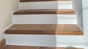 A staircase with white painted steps and wooden risers, leading to a landing.