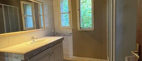 Chuveiro, toalhas de banho, sabonete, papel higiênico