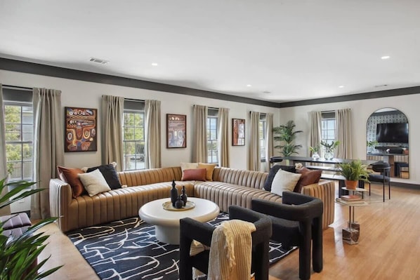 A modern living room with a sectional sofa, a coffee table, and a television.