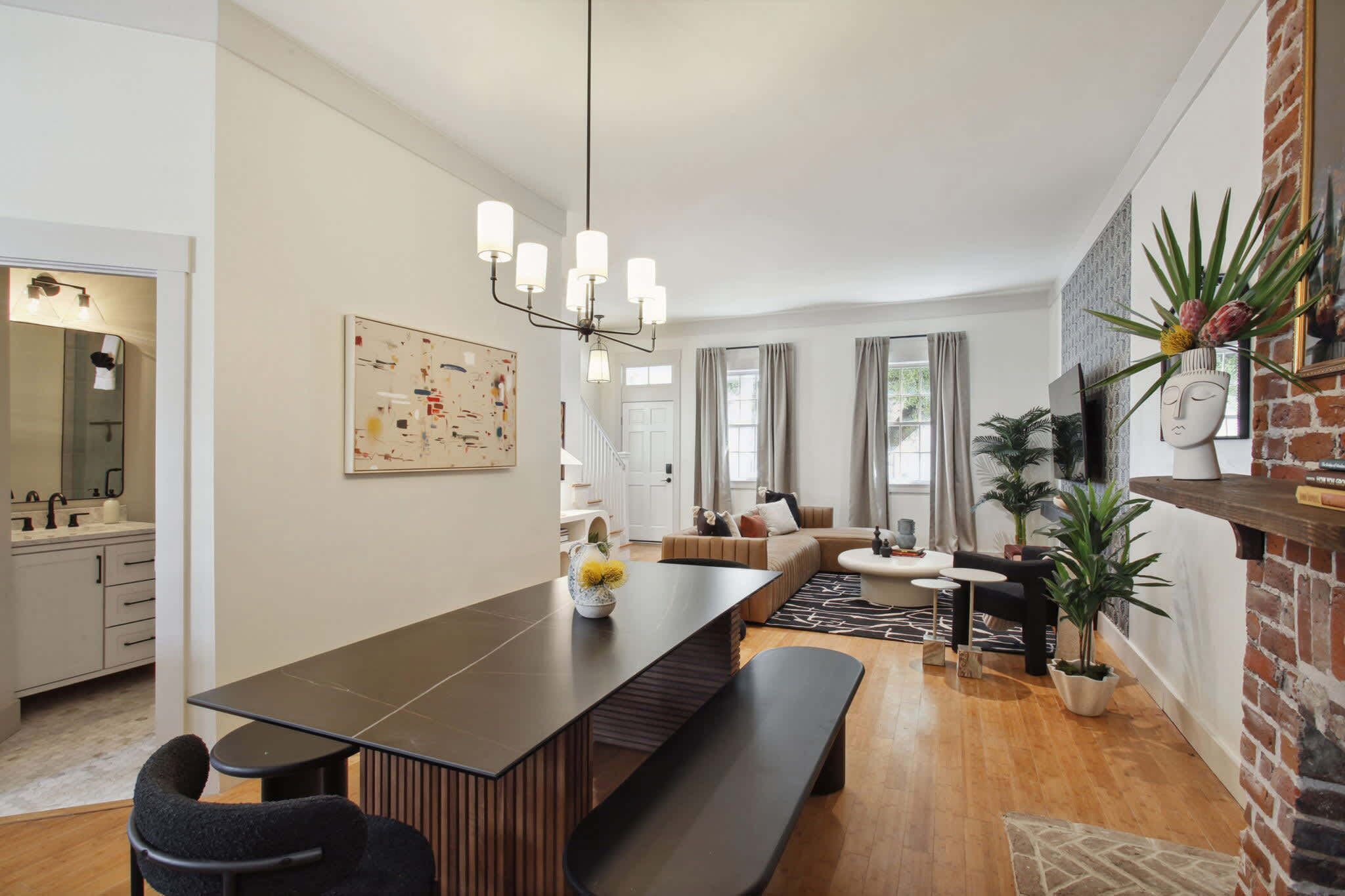 Een moderne woonkamer met een lange eettafel, een bankje en een bank.