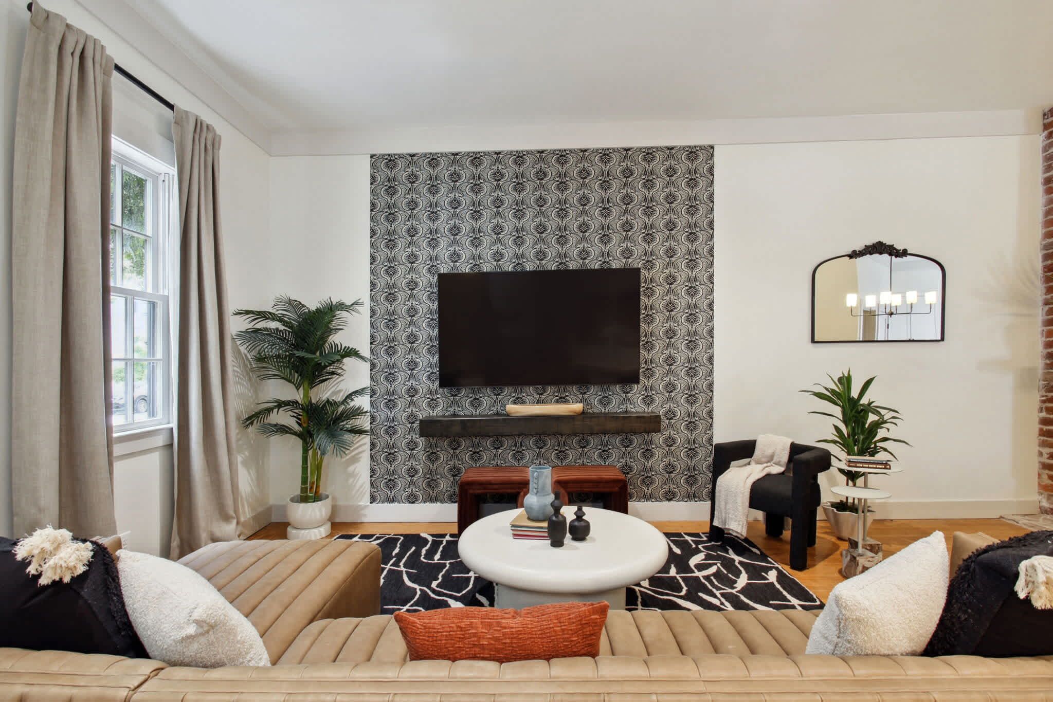 A modern living room with a sofa, a coffee table, a TV, and a fireplace.