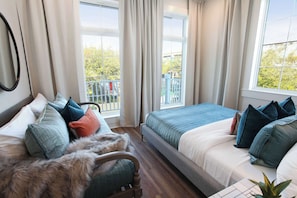 Een slaapkamer met twee bedden, een stoel en uitzicht op een balkon.