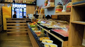 Un espace buffet proposant une variété de plats, notamment des fruits et des viandes, dans un cadre de restaurant.