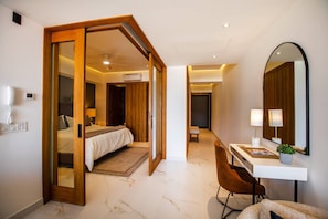 Habitación de hotel con cama, escritorio, silla, espejo y baño.