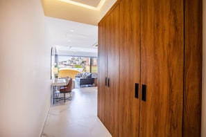 Un interior moderno con un armario de madera, una zona de comedor con mesa y sillas, y vistas a edificios.