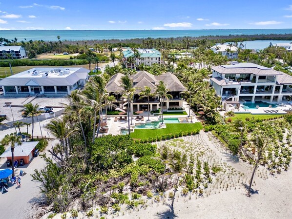 A resort with multiple buildings, a swimming pool, and a beach area.
