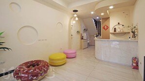 Un interior moderno con una zona de cocina, un comedor y una sala de estar con taburetes de colores.