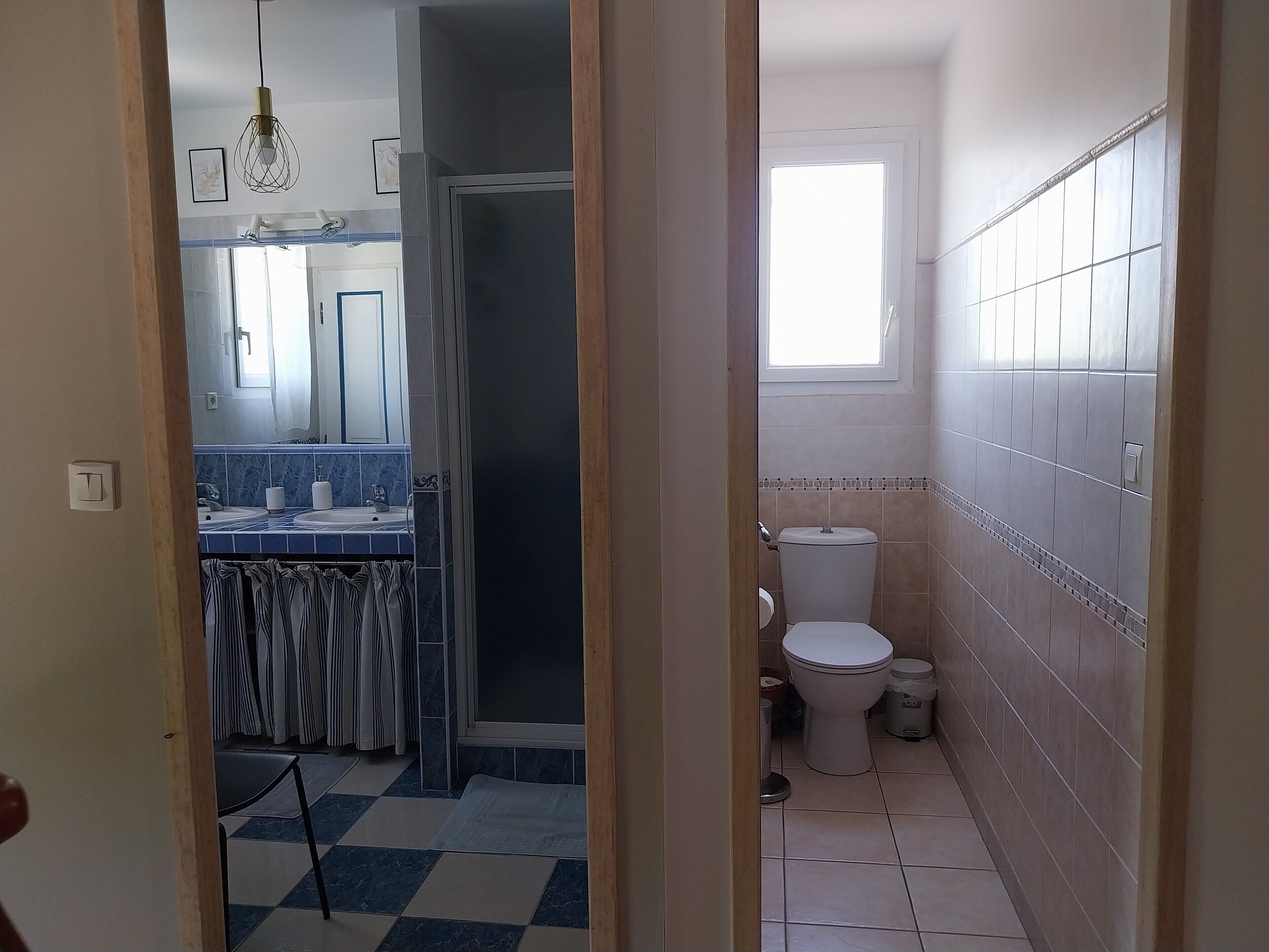 Un bany amb vàter, rentamig i zona de dutxa.