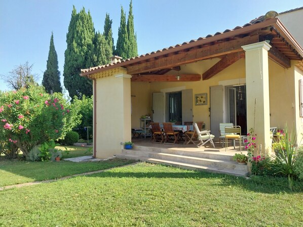 A covered patio with outdoor furniture, a dining table, and chairs. - Beautiful villa, green setting with swimming pool, quiet 800m from the center (Saint-Rémy-de-Provence)