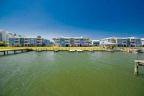 Un hotel frente al agua con varios balcones, un muelle y vistas despejadas.