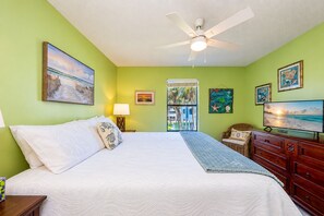 A bedroom with a bed, a dresser, a ceiling fan, and wall art. - Sea Oats 105h 3 Bedroom Condo (Gulf Shores)