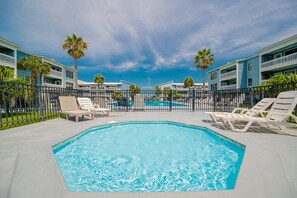A swimming pool with lounge chairs, a clear sky, and a building with balconies. - Sea Oats 105h 3 Bedroom Condo (Gulf Shores)