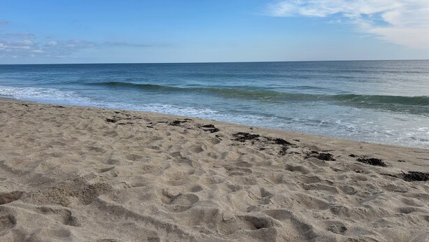 Een strand met zand en golven.