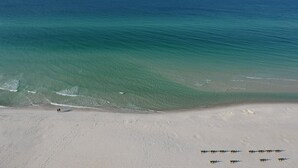 Una spiaggia con acque limpide e una costa sabbiosa.