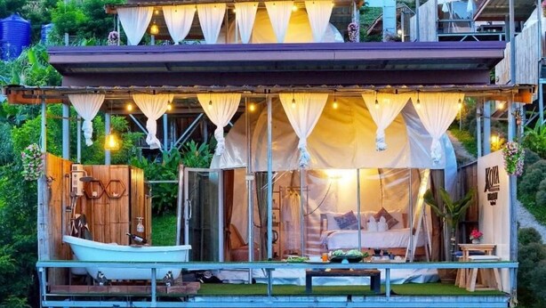 A floating wooden structure with a bed, a small table, and a hanging light fixture. - Koya Homestay (Mae Rim)