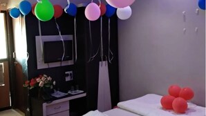 Een slaapkamer met een bed, een kaptafel met spiegel en een tafeltje met een bloevas.